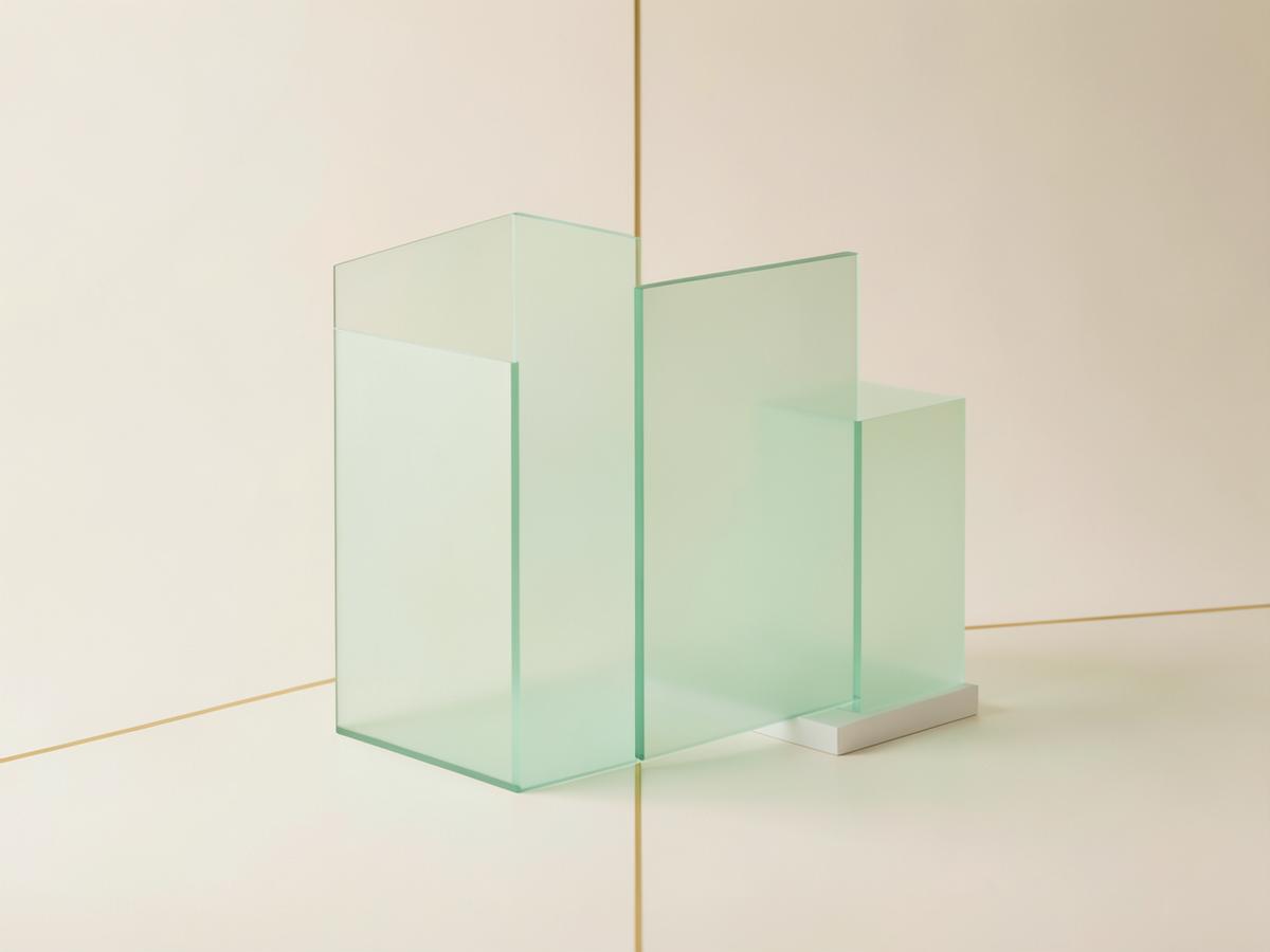 Soft green frosted-glass shapes arranged on a warm neutral background